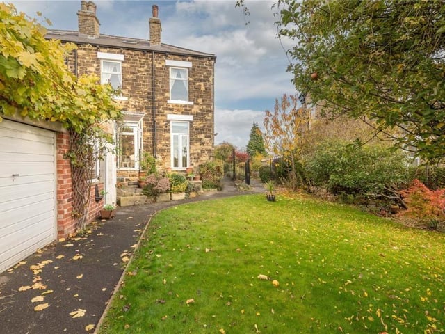 The lawned garden has mature trees and shrubs surrounding it.