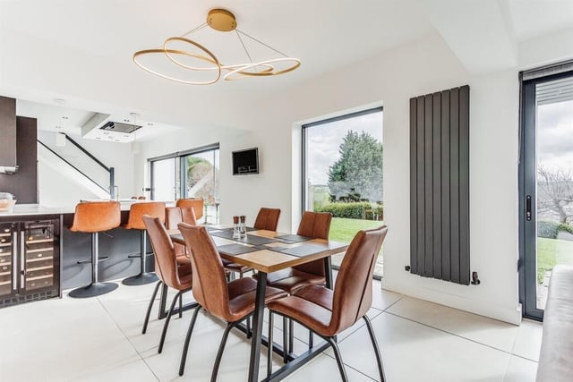 The dining area, adjacent to the open plan kitchen with island.