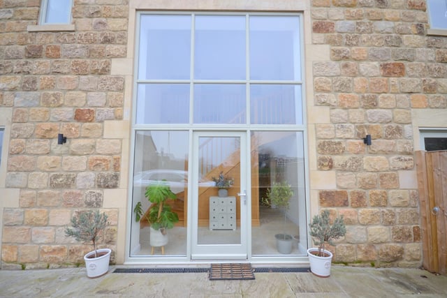 Full-length glass panels in windows and door panels make a striking feature to the front of the property.