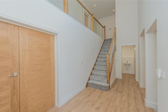 This spacious feature has a full height hallway with glazed timber stairs.