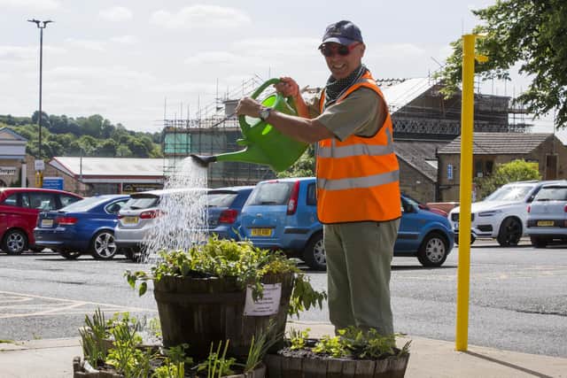 Ex-council gardener, Peter Fawcett, watering the plants in Cleckheaton.
