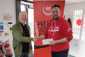 Fr George presenting the funds raised to Andrew Hardill, Director of Operations at SKT