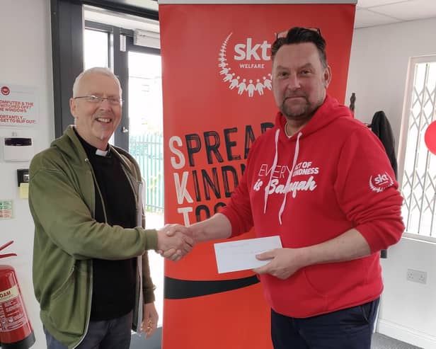 Fr George presenting the funds raised to Andrew Hardill, Director of Operations at SKT