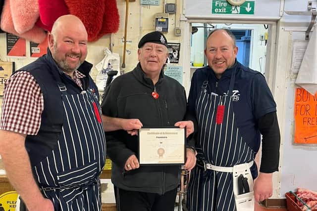 Tim Wood, centre, presents an award to Haigh's Farm Shop for the firm's 25 years of support to local veterans.