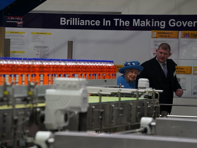 Queen Elizabeth II with Chief Executive Roger White in the bottling plant during a visit to AG Barr's factory in Cumbernauld.
