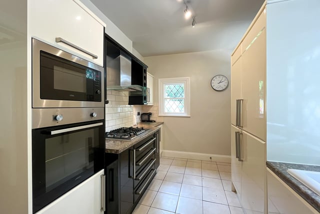 A modern breakfast kitchen has a range of appliances, a breakfast bar and a useful walk-in pantry,