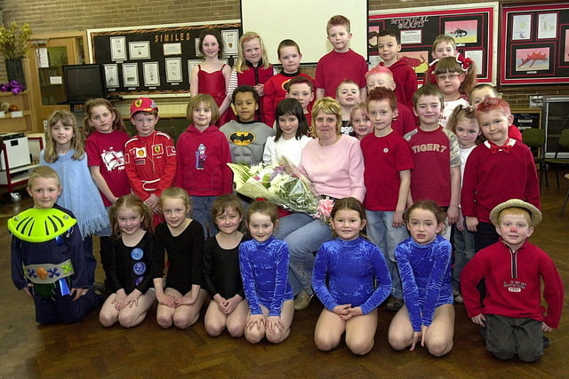 Susan Heeley, who was leaving her post as cook at Hanging Heaton School after thirteen years, with pupils at the school who performed to mark Red Nose Day in 2005