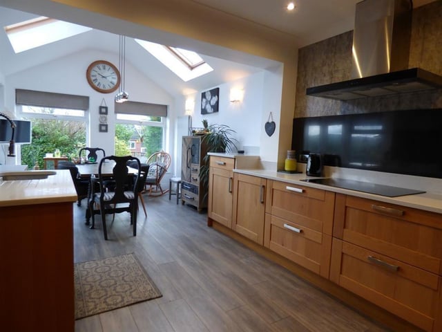The dining area adjoining the kitchen has large feature windows.