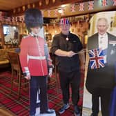 Tim Wood with the lifesize cardboard cutouts of King Charles III and the Queen Consort at the Old Colonial.