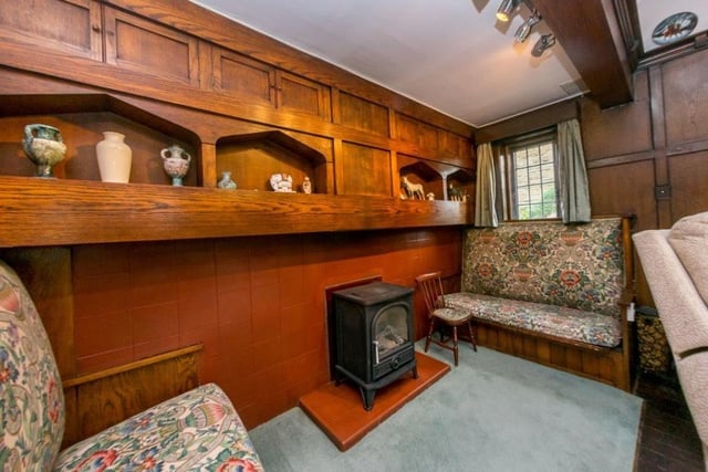 Built-in wooden furniture is above the stove set upon a hearth in the spacious lounge.