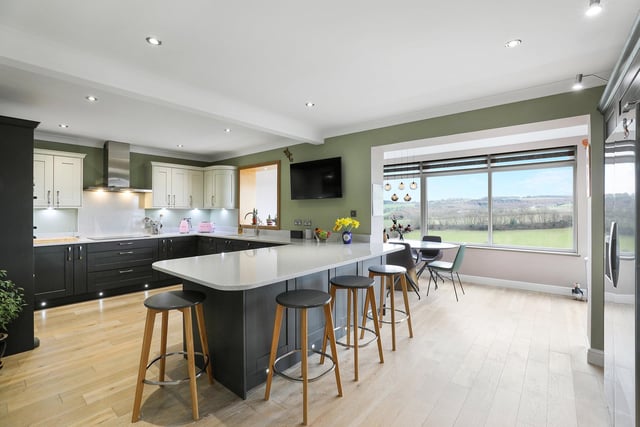 The breakfast kitchen has shaker-style units with quartz worktops, and integrated appliances.