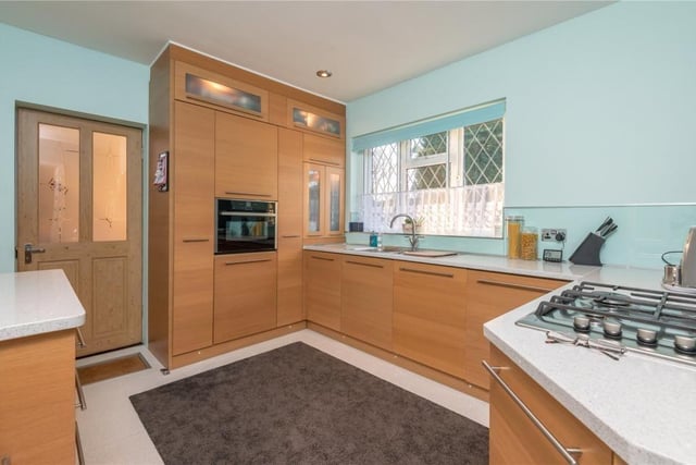 A spacious, fitted kitchen with spotlights, and granite worktops, has a built in 'NEFF' electric oven with gas hob and extractor fan, along with a fridge, dishwasher and microwave.