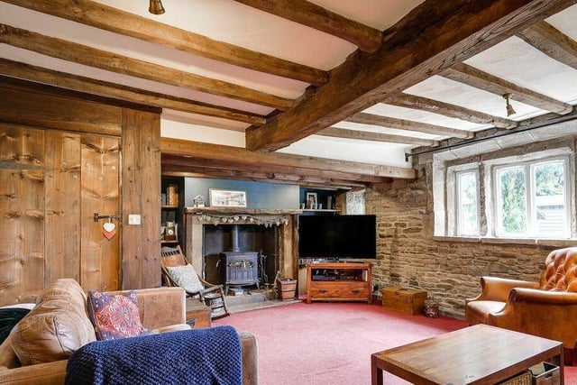 An exposed stone wall and an inglenook fireplace are among the original features in the lounge.