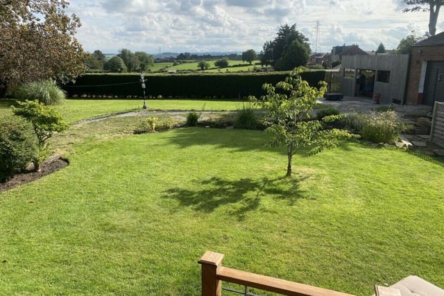 The private garden with seating areas has open countryside views.