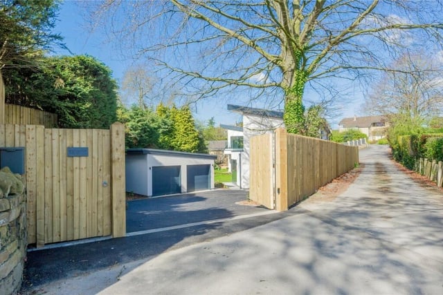 The property features an electronically controlled security gate, ample driveway parking and a double detached garage.