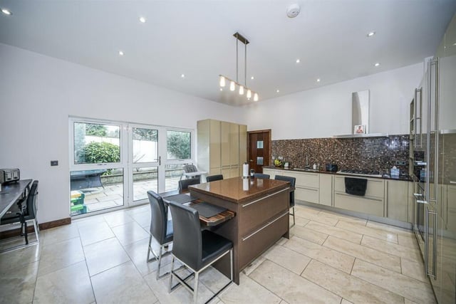 The high spec kitchen with central island includes Miele appliances, with a separate fitted utility room.