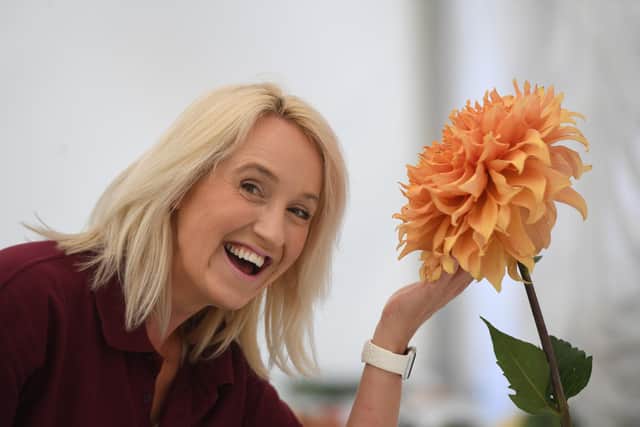 Volunteer Jodie Asquith with Giant Dahlia in the flower show. Photo: Gerard Binks