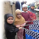 Some children at the procession with blue and green Sufi-Muslim flags - and flowers of peace attached on their flags