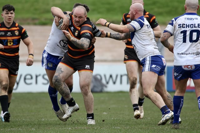 Dale Ferguson aims to brush off Workington tacklers.