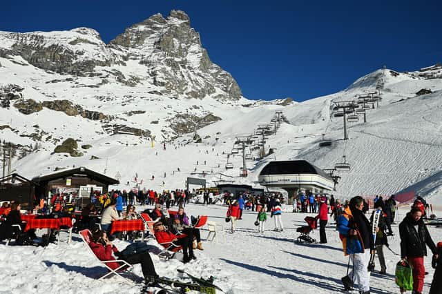 Tourists ski and rest in the sun under the Matterhorn mount (Monte Cervino) in the alpine ski resort of Breuil-Cervinia, northwestern Italy, on December 31, 2021. (Photo by Vincenzo PINTO / AFP) (Photo by VINCENZO PINTO/AFP via Getty Images)