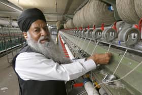 Mr. Afzal doing some 'piecening' work on a Spinning Frame Machine.