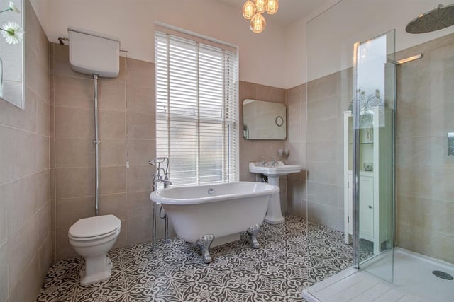 A bathroom with corner shower and free standing bath.