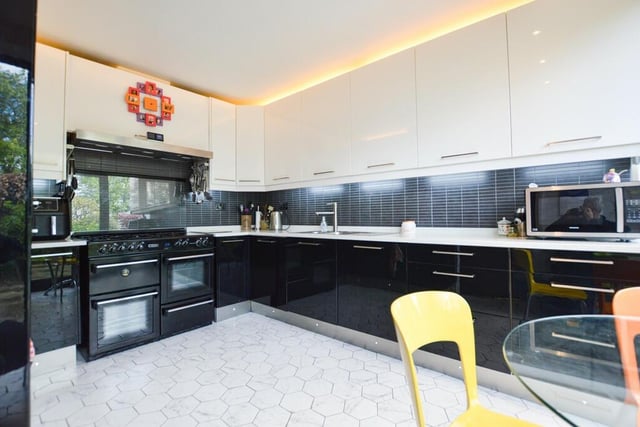 The modern kitchen has high gloss units with a range-style oven and further integrated appliances.