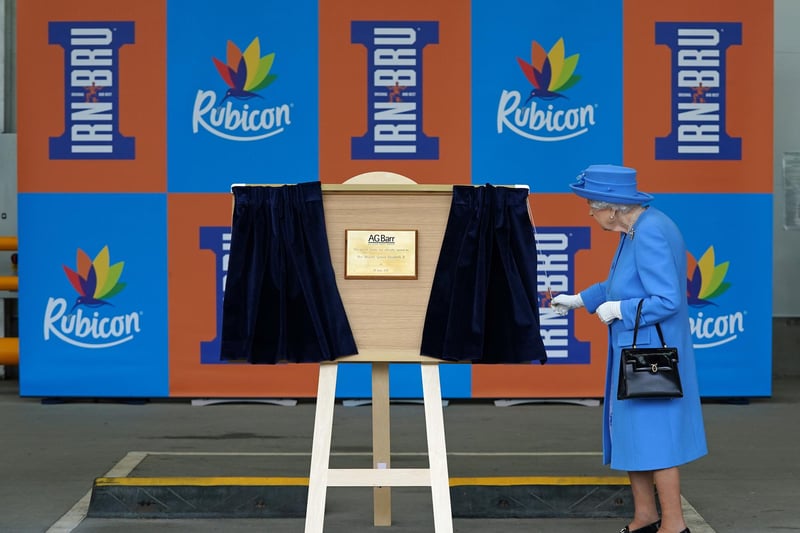 Queen Elizabeth II unveils a plaque at the factory.