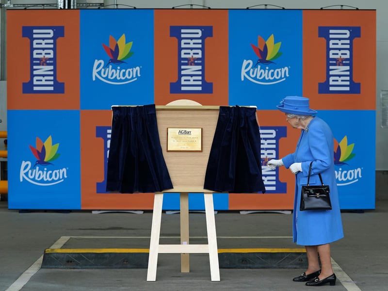 Queen Elizabeth II unveils a plaque at the factory.