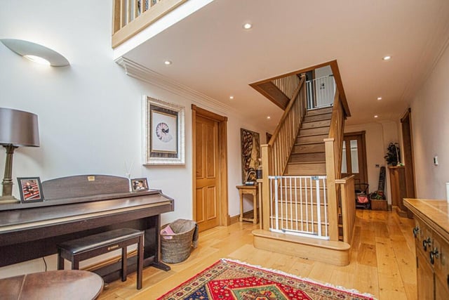 The bright hallway, with solid oak floor and staircase.