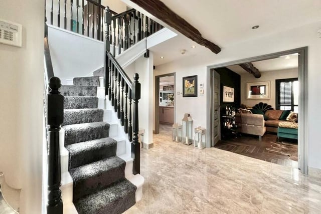 A spacious hallway with staircase leads to ground floor rooms.
