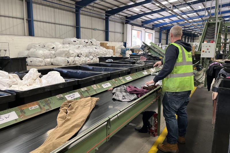 Oxfam's production manager, Graeme, sorting through garments at the National Sorting Centre.