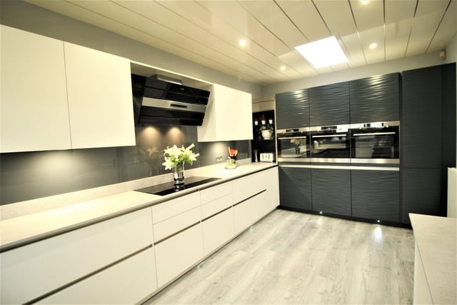 A super-sleek kitchen with integrated appliances and an electric Velux window.