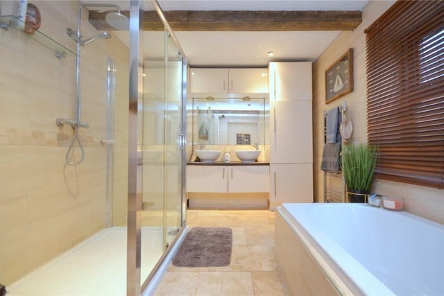 A luxurious bathroom with double washbasin vanity unit and large walk-in shower.