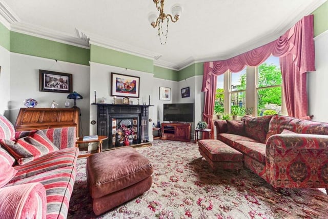This bay-fronted reception room has a traditional slate fireplace with tiled and cast iron inset for an open fire.