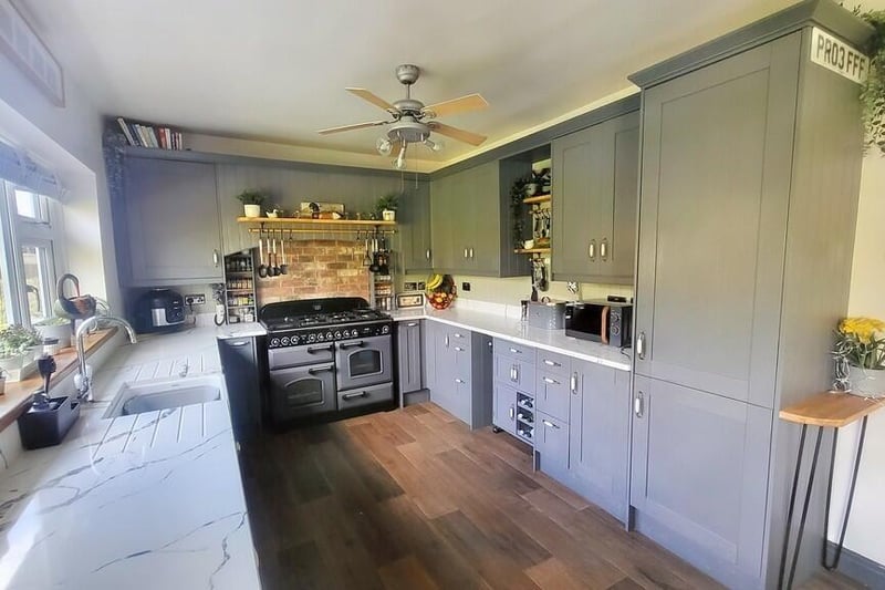 The spacious dining kitchen is fitted with a range of wall and base units with quartz worktops and matching upstands, a Belfast sink, a range style cooker with extractor over, and an integrated fridge/freezer and dishwasher.