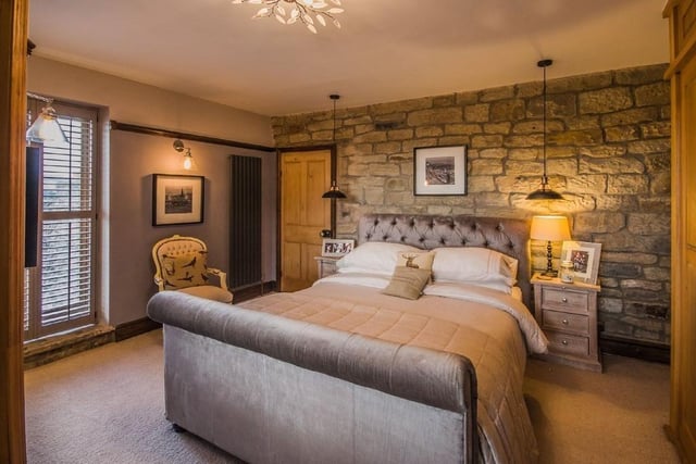 A double bedroom with exposed stone feature wall.