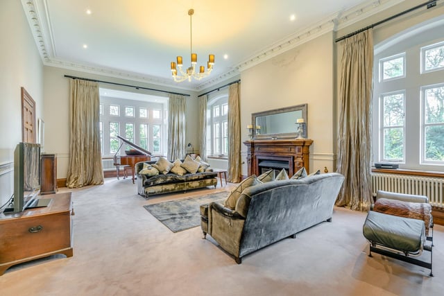 Period features in this room with an open fire include the oak fireplace with marble inset, deep oak skirting boards, architraves and ornate coving, with stone mullioned surrounds to windows.