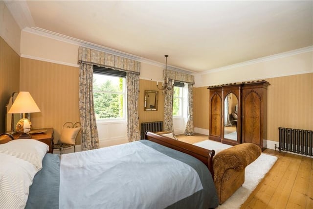 The principal bedroom enjoys dual aspect over the gardens through original sash windows, carved traditional wardrobes, a cast iron open fireplace with marble surround and a large ensuite bathroom.