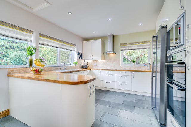 Cream fitted units with wooden worktops and integrated appliances that include a double oven and dishwasher are to be found in the kitchen.