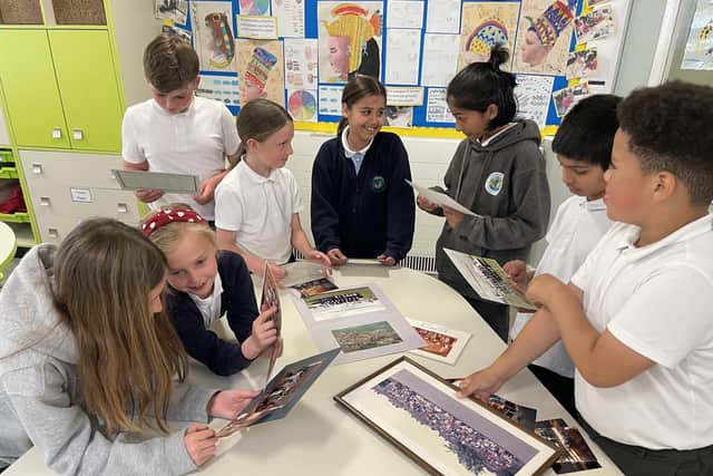 Pupils at Crossley Fields enjoying some of the old photos the school has already received ahead of the 30th birthday celebrations.