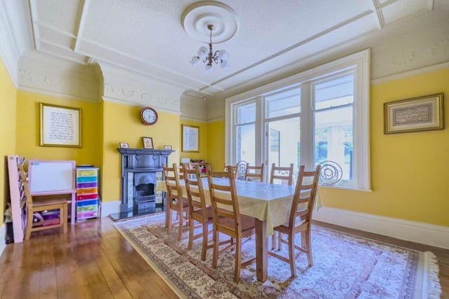 A bright and spacious dining room with ornate cast iron fireplace and period decorative features.