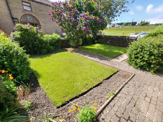 Mature gardens with trees and shrubs have countryside beyond