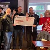 Janet Lonsdale (right) and Ian Thornton (third from left), OLSC members, present the cheque to Stephen Hubbard (second from left), of Andy's Man Club
