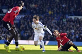 Leeds United goal scorer Brenden Aaronson takes on two Manchester United defenders.