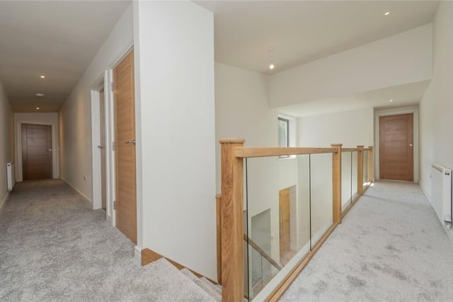 This galleried landing has glazed balustrade, a storage cupboard and thermostat heating controls on both levels.