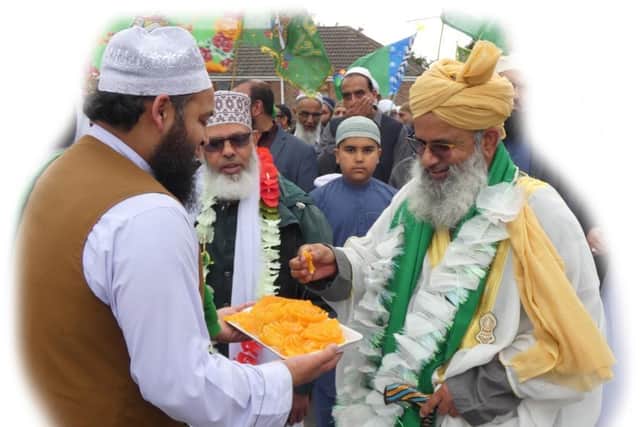 Heckmondwike resident Haroon Al-Hashmi offering some Indian sweets to senior Muslim Scholar Mufti Allama-Moalana Shamsul-Huda Khan Misbahi during this year's procession