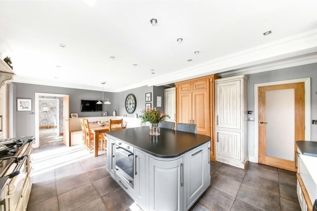 The fabulous dual aspect kitchen has sliding glass doors opening to the front, fitted units to base and wall level, a central island with wine fridge, integrated appliances, a dual fuel Aga and a dining area with ample space for a family sized dining table and chairs.