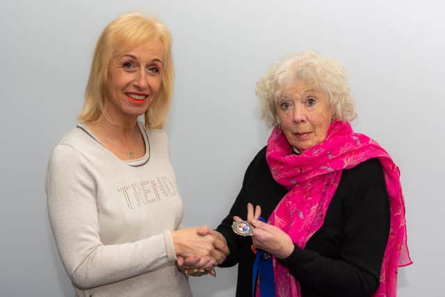 Jean Jackson (right) passing the presidents medal to Sarah Tolson (left).