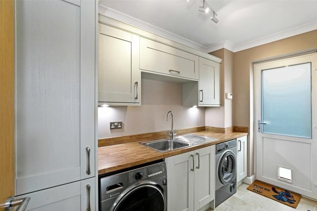 The utility room is fitted with a matching range of shaker style fronted wall and base units, contrasting worktop areas, a stainless steel sink unit, a single drainer, plumbing for automatic washing machine and space for a dryer.